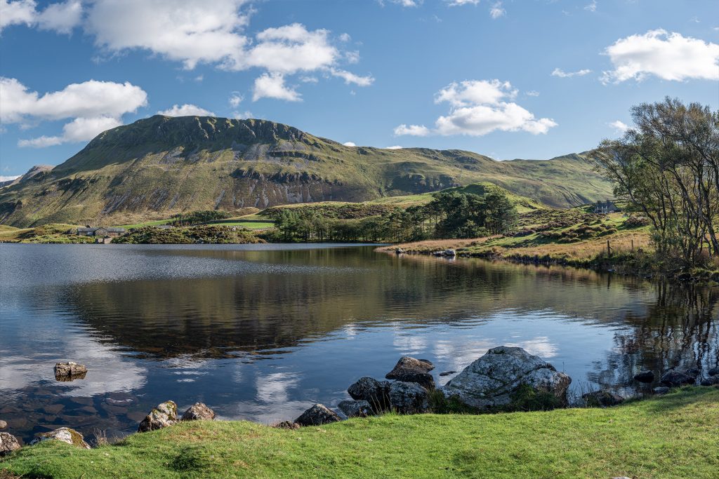 Bergdal met een kronkelende rivier tussen groene hellingen, ontwerp voor een LED-fotowand