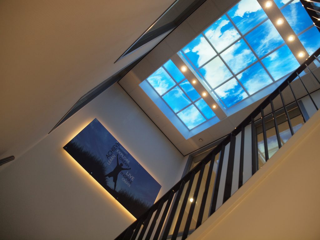 Trappenhuis van Albeda College met een groot LED-fotoplafond met wolkenlucht